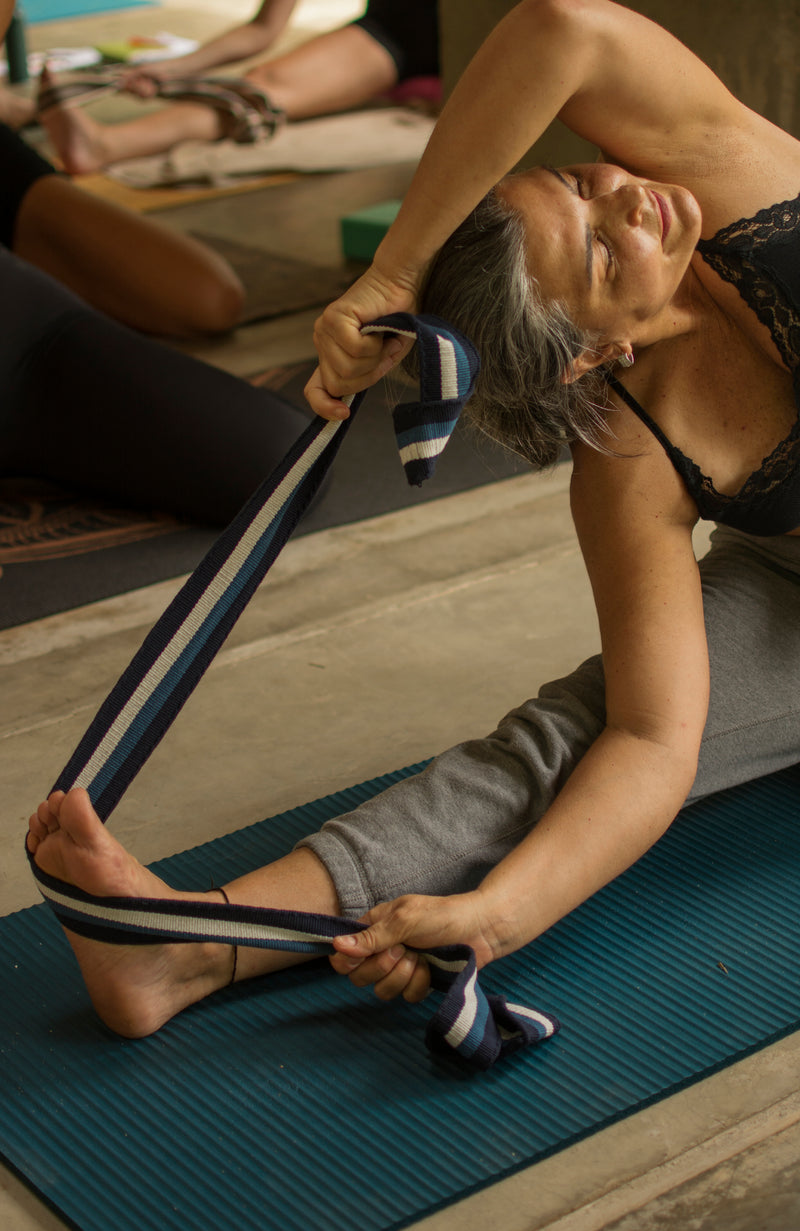 Woman using a Catalina strap to stretch during yoga