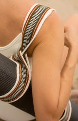 Close up of a woman carrying a yoga mat over her shoulder with a Catalina strap attached