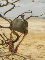 Close up of the Urban Safari handbag in Olive, hanging from a tree branch
